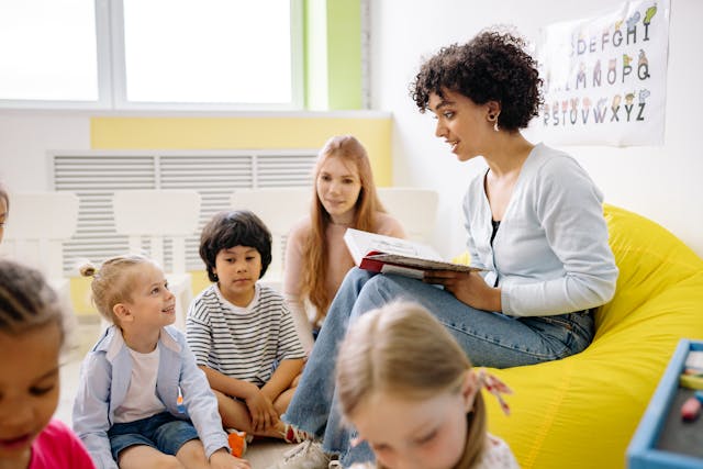 Teacher reading from a book to gathered students