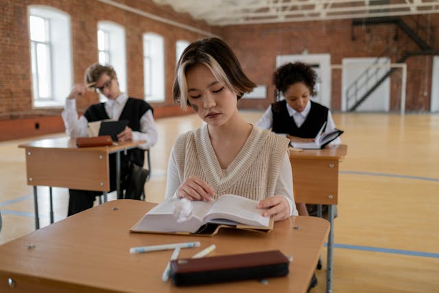 Schoolgirl reading a thick book at her desk