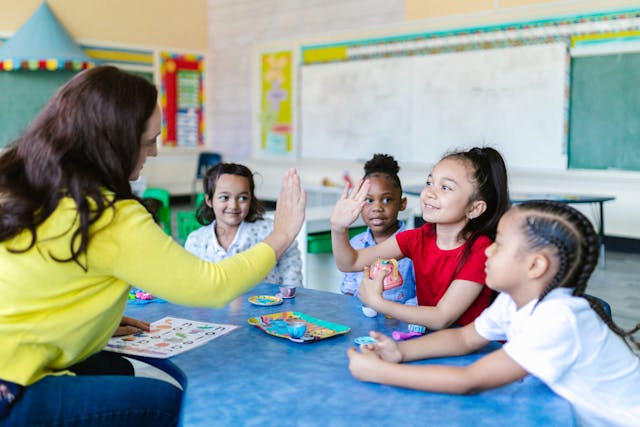 Teacher high-fiving a kid during a group study session